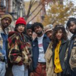 A group of young, diverse people standing together in an urban setting.